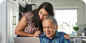Woman in blue sweater smiling while talking into a headset
